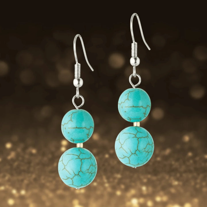Turquoise and Tiger's Eye Earrings featuring two round turquoise stones with gold plating on sterling silver hooks, designed for a sophisticated female jewelry style.