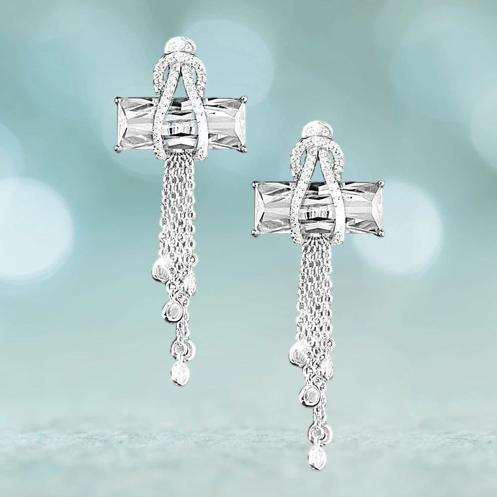 Contemporary Cross Clear Earrings crafted from sterling silver with rhodium plating, featuring clear stones and delicate cascading chains for an elegant feminine jewelry statement.