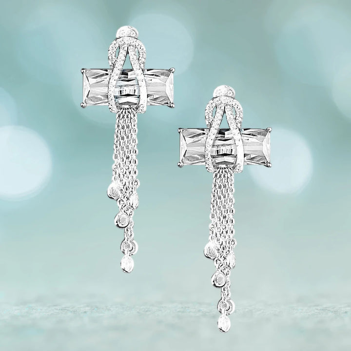Contemporary Cross Clear Earrings crafted from sterling silver with rhodium plating, featuring clear stones and delicate cascading chains for an elegant feminine jewelry statement.
