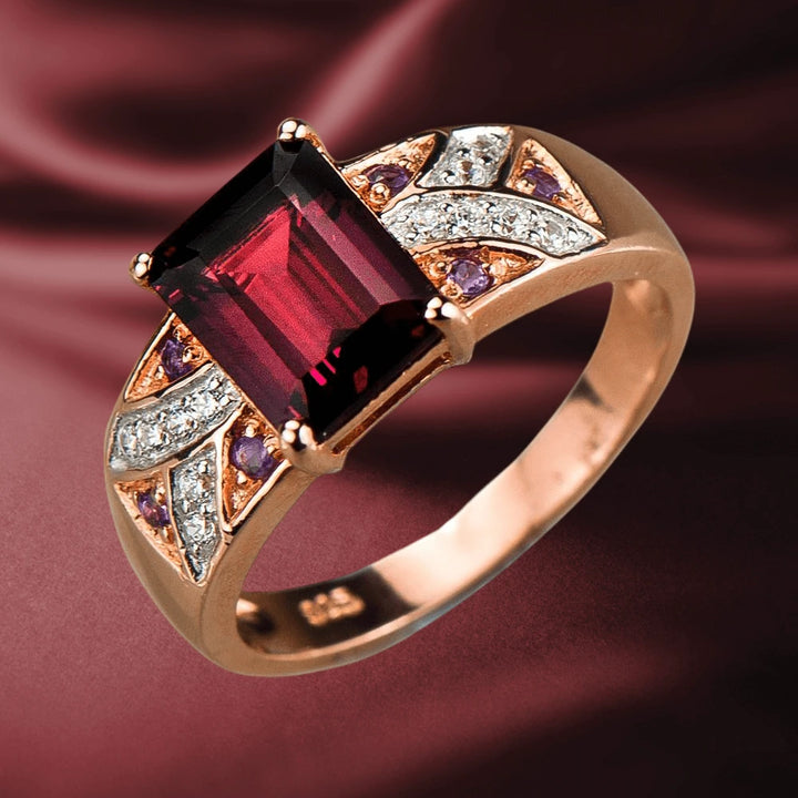 Carnation Garnet Ring featuring a large rectangular garnet centerpiece set in sterling silver with rose gold plating, accented by sparkling white and purple stones for women’s jewelry.
