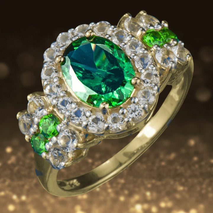 OZ Ring featuring a gold plated sterling silver band with a large oval green gemstone centerpiece surrounded by small clear stones, designed for women’s jewelry.