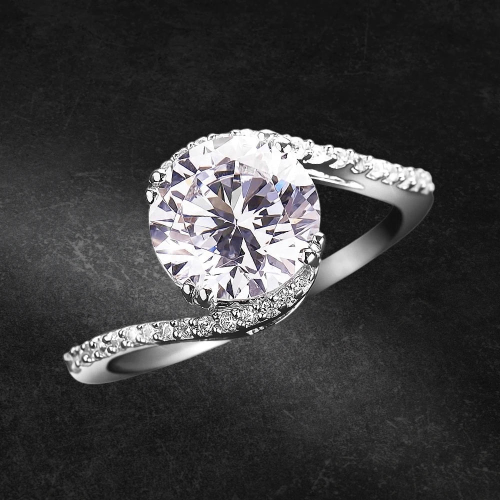 Embrace Solitaire Ring in sterling silver with rhodium plating, featuring a large round solitaire stone and a delicate band adorned with smaller sparkling stones for women’s jewelry.