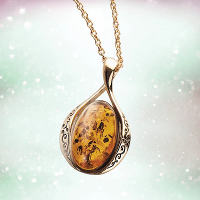 Elegant Baltic Amber Pendant designed for female wearers, featuring a polished sterling silver setting with gold plating and intricate detailing on the sides.