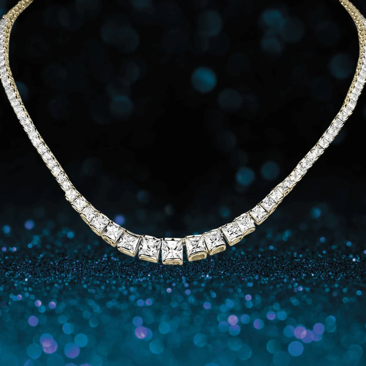 Elegant Starlet Gold Necklace featuring a row of sparkling square-cut stones designed for women, set against a shimmering dark blue background.