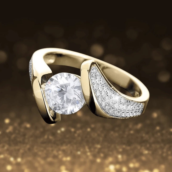 Regalia Twist Ring in sterling silver with gold plating, featuring a sparkling round stone and pavé accent details, designed for women’s elegant jewelry collections.