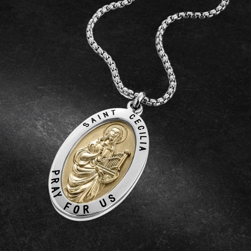 Stainless steel St Cecilia Pendant featuring a detailed gold-tone saint figure holding a harp, with the inscription 