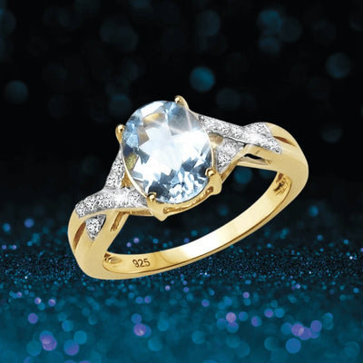 Majorelle Blue Topaz Ring featuring a sterling silver band with gold plating, showcasing an oval blue topaz center stone and accented with sparkling clear gemstones.