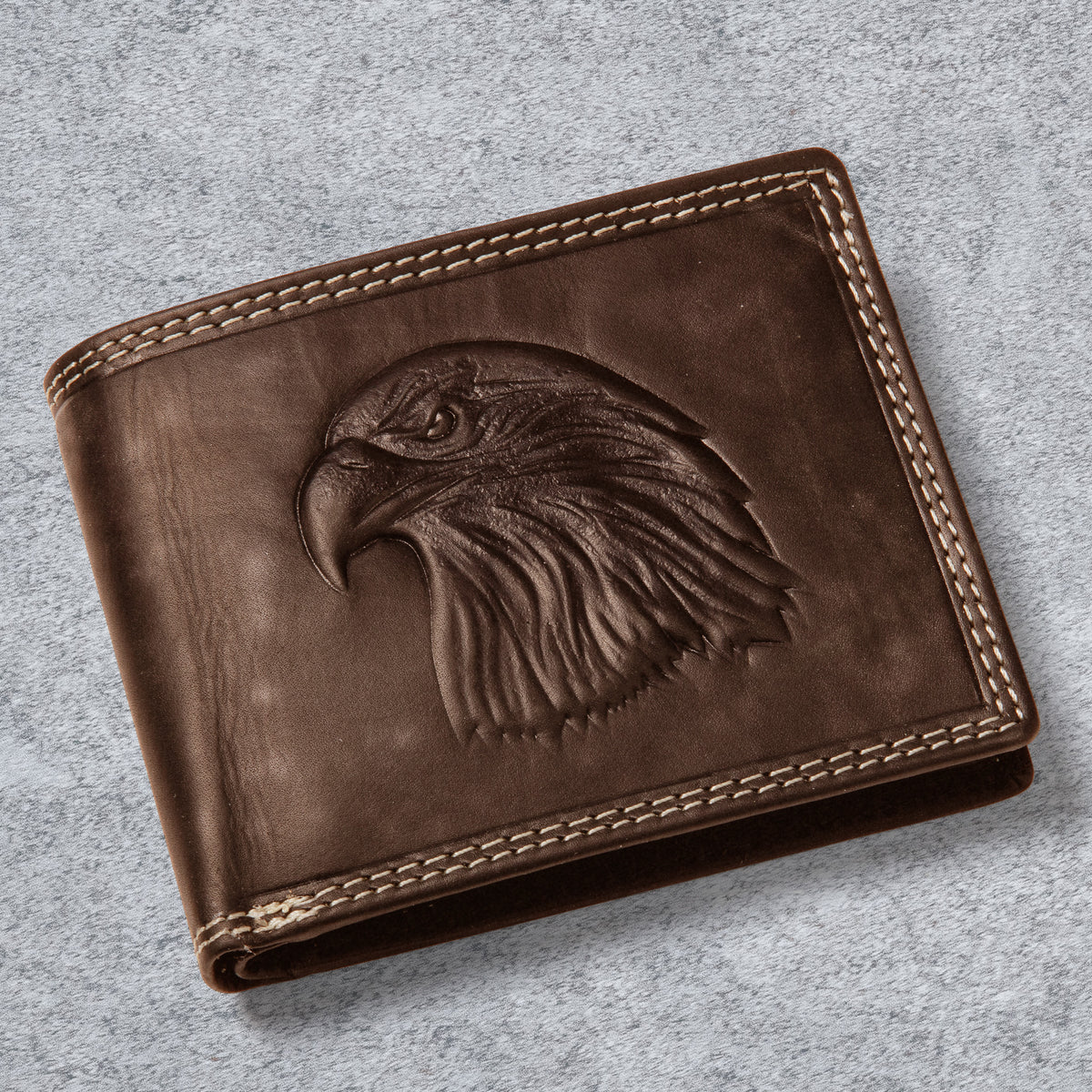 Eagle Predator Leather Wallet in brown leather with a detailed embossed eagle head and contrasting stitched trim on a soft gray surface Up To 75% Off Retail
