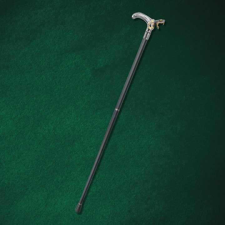 Black Fang Walking Cane with a sleek black shaft and a silver handle featuring a detailed wolf head design, resting on a dark green surface.