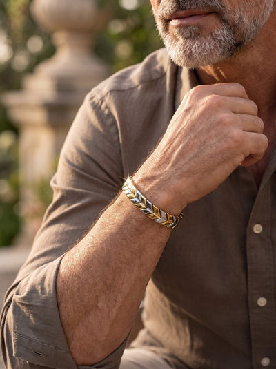 Lorenzo Bracelet featuring gold and silver geometric links on a mans wrist styled with a brown shirt in warm outdoor light