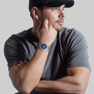 Man wearing steel watch with blue dial
