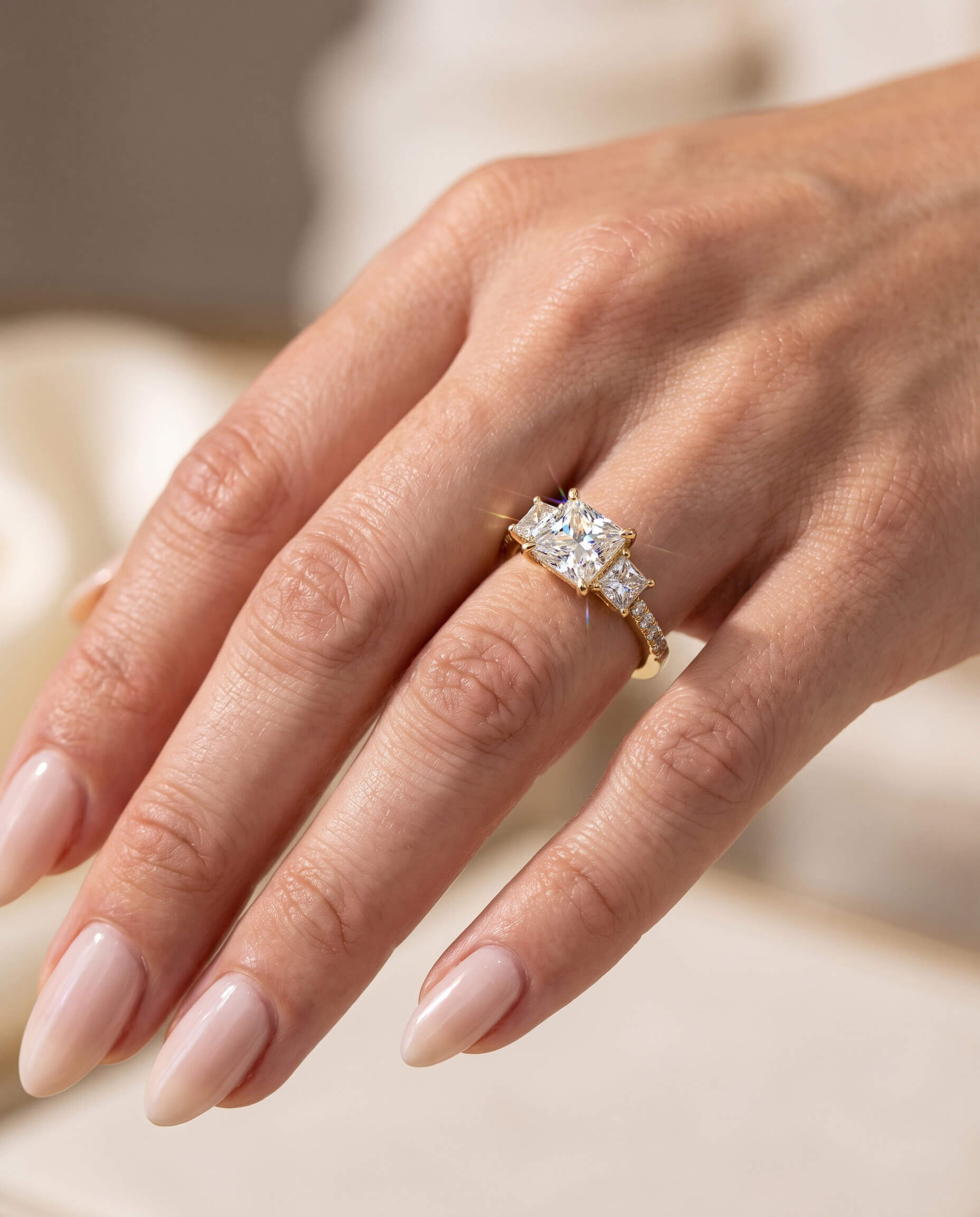 Close-up of a hand wearing the Verity Ladies Ring with a square-cut sparkling gemstone on a gold band, showcasing elegant jewelry Up To 75% Off Retail.