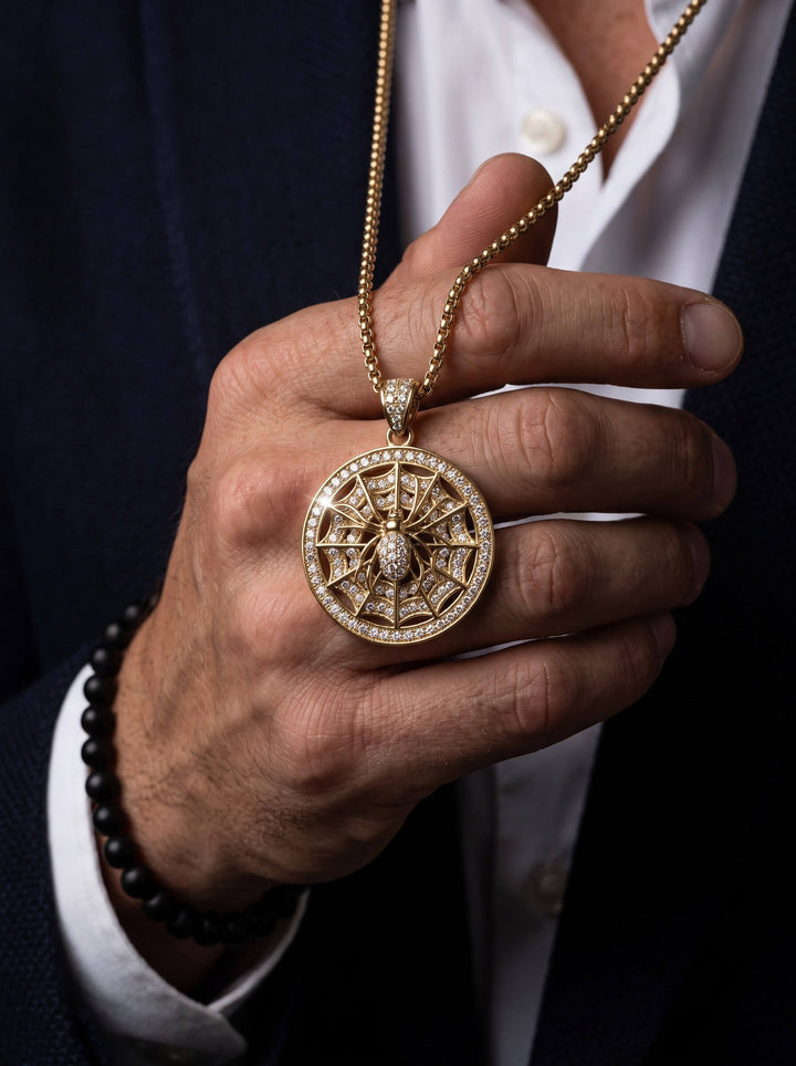 The Webmaster Pendant ornate circular gold necklace pendant with intricate web design and sparkling accents held in a hand Up To 75% Off Retail