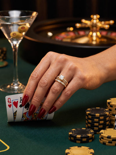 Juliet Bridal Ring worn on a hand above playing cards and poker chips beside a martini glass Up To 75% Off Retail