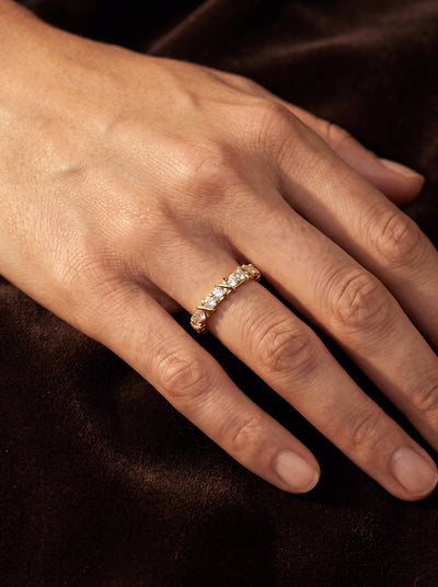 Golden Kiss Ladies Ring with a sparkling gold band and clear stones worn on a hand against dark satin Up To 75% Off Retail