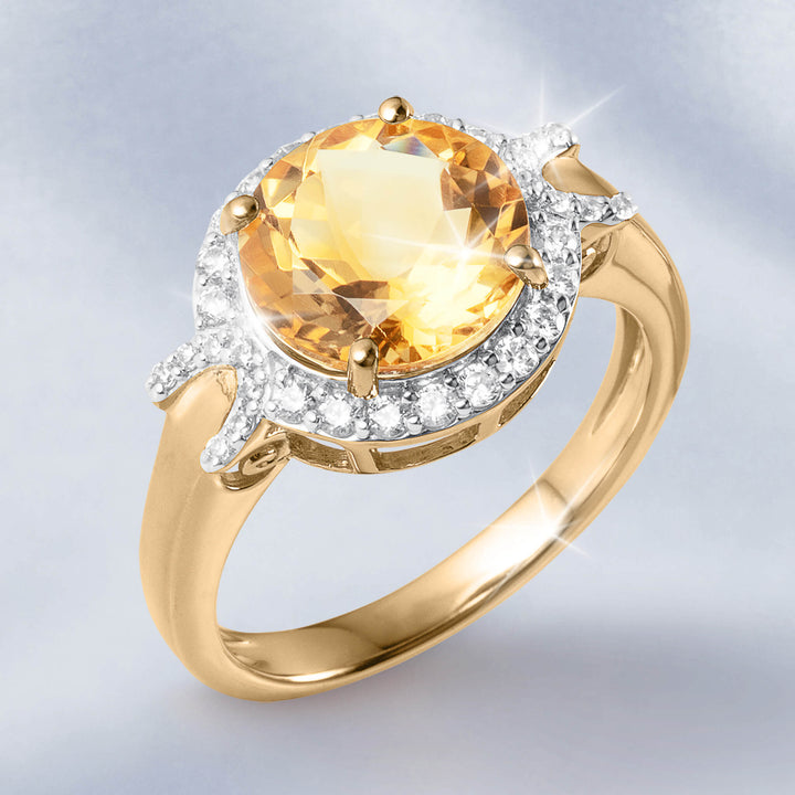 Gold ring with a large faceted yellow gemstone surrounded by sparkling clear stones on a polished band