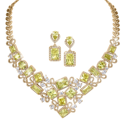 Ornate gold tone necklace and matching drop earrings featuring lime green gemstones and clear crystal accents arranged in an elaborate geometric design