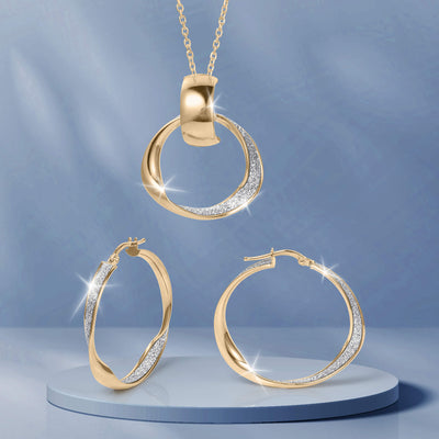 Serena Collection gold jewelry set featuring a crystal accented pendant necklace and matching hoop earrings displayed on a pedestal Up To 75% Off Retail
