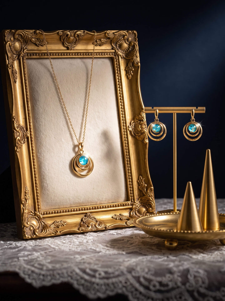 Baltic Lagoon Pendant featuring a luminous blue cabochon set in layered gold toned jewelry styled with an ornate frame and coordinating blue earrings