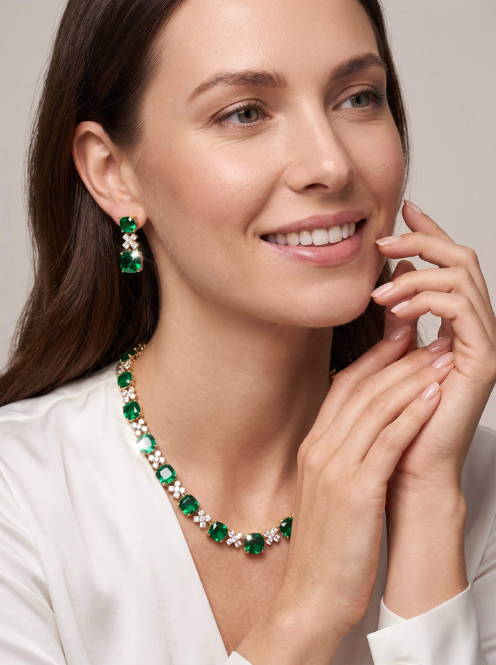 Freya Necklace featuring sparkling green crystal accents on a smiling woman in a white blouse. Elegant jewelry styling for a refined statement look. Up To 75% Off Retail