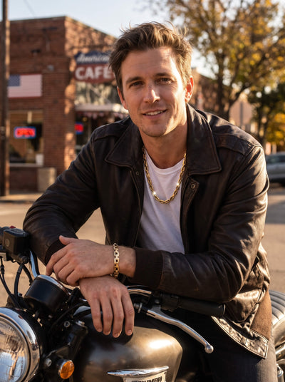 Moderna Link Bracelet in gold tone worn on a mans wrist as he sits on a motorcycle in a leather jacket, showcasing refined link jewelry style
