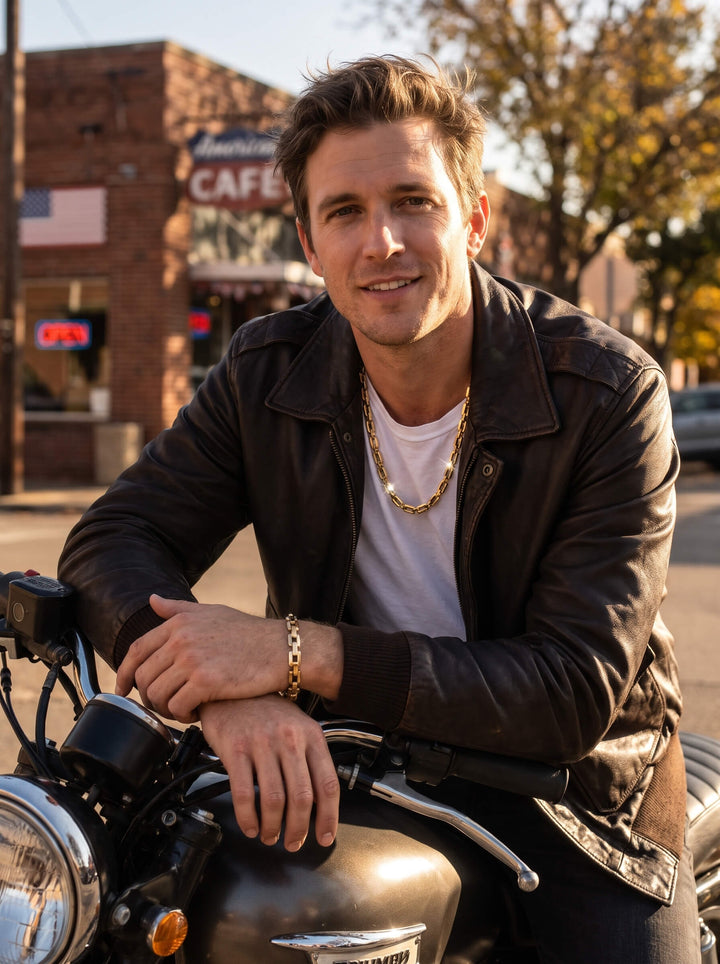 Moderna Link Bracelet in gold tone worn on a mans wrist as he sits on a motorcycle in a leather jacket, showcasing refined link jewelry style