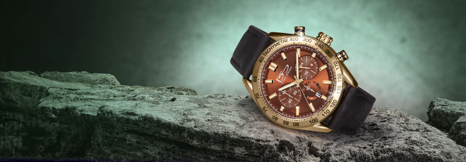 Luxury watch with brown face and gold accents on a dark, textured surface