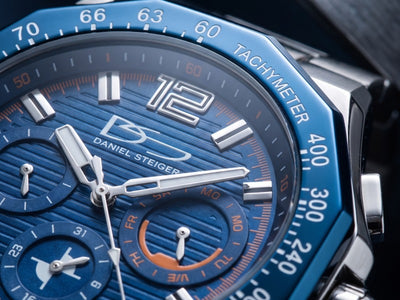 Ultima Men's Watch close up with blue chronograph dial silver hands tachymeter bezel and Daniel Steiger detailing