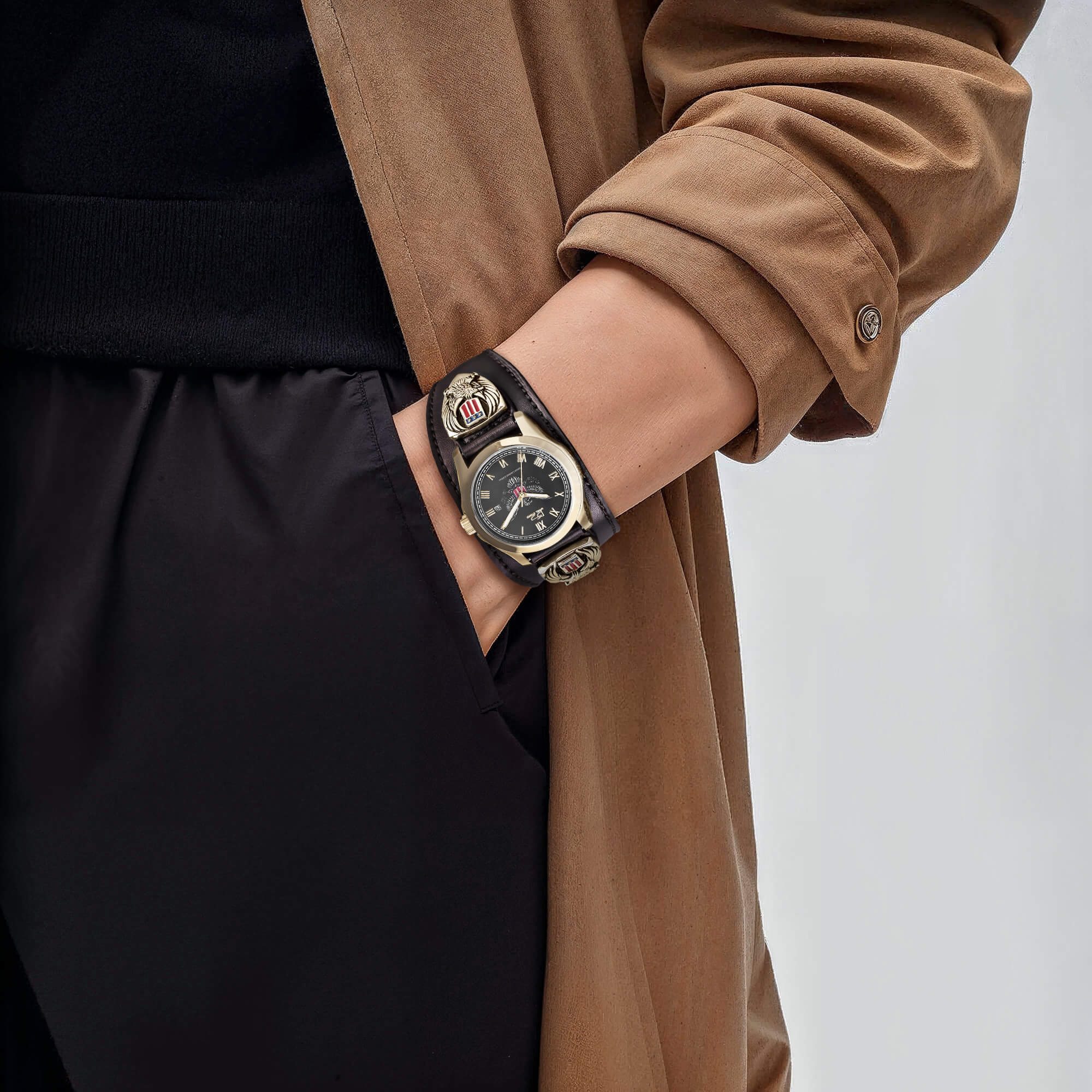 Patriot Men's Watch featuring a black dial, gold plating, and stainless steel construction worn on the wrist with a layered brown coat and black pants.