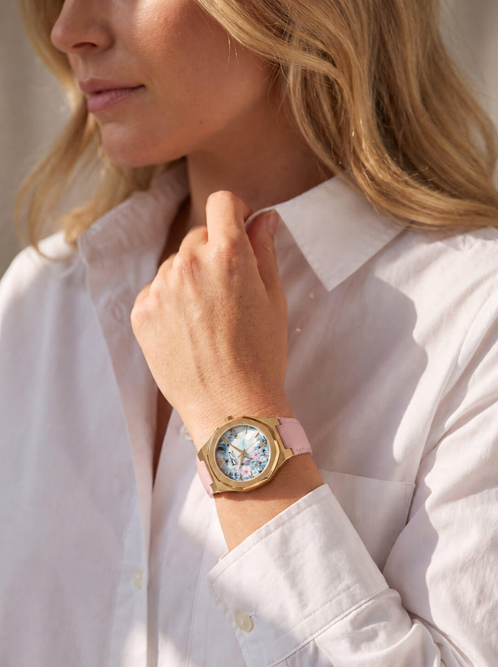 Fleur De Vie Ladies Watch with floral dial and pink strap worn by a woman in a white shirt Up To 75% Off Retail