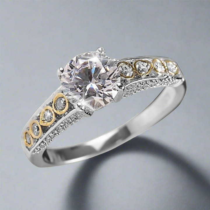 Romana Ring featuring a two-tone sterling silver band with intricate detailing and a large sparkling center stone, designed for women’s jewelry collections.