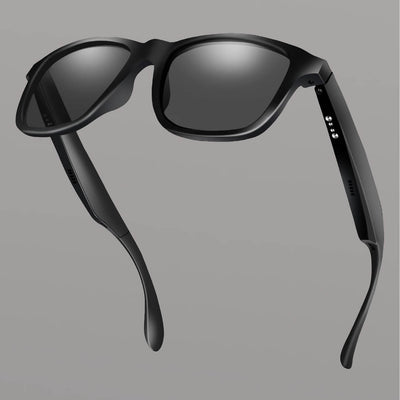 Black smart sunglasses with reflective lenses on a gray background