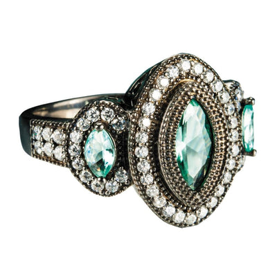 Black Orchid Ring featuring sterling silver with an intricate design showcasing oval blue stones surrounded by sparkling clear crystals, elegant female jewelry piece.