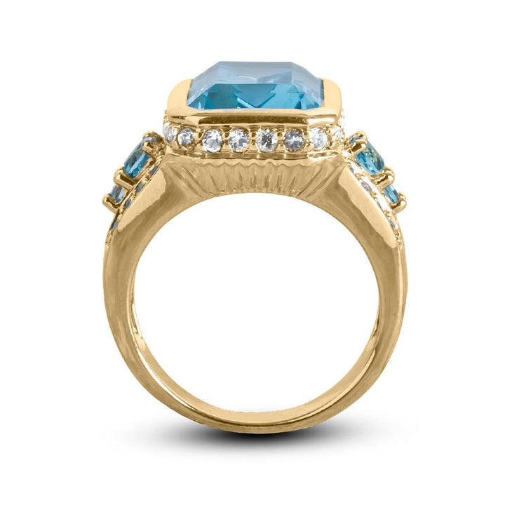 Bermuda Blue Topaz Ring featuring a large rectangular blue topaz centerpiece set in sterling silver with gold plating and accented by smaller blue and clear stones, designed for female wear.