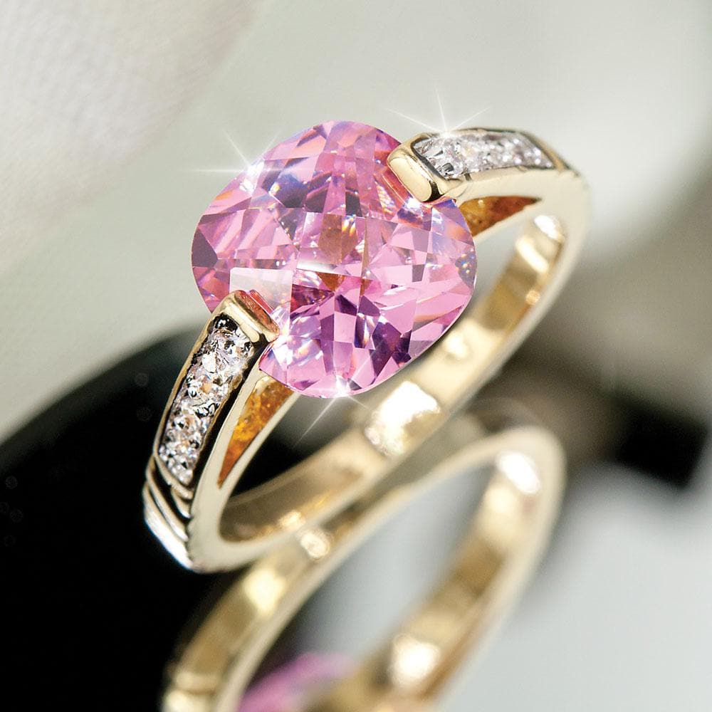 Carina Ring featuring a gold-plated sterling silver band with a large cushion-cut pink gemstone and small clear accent stones, designed for women’s jewelry collection.