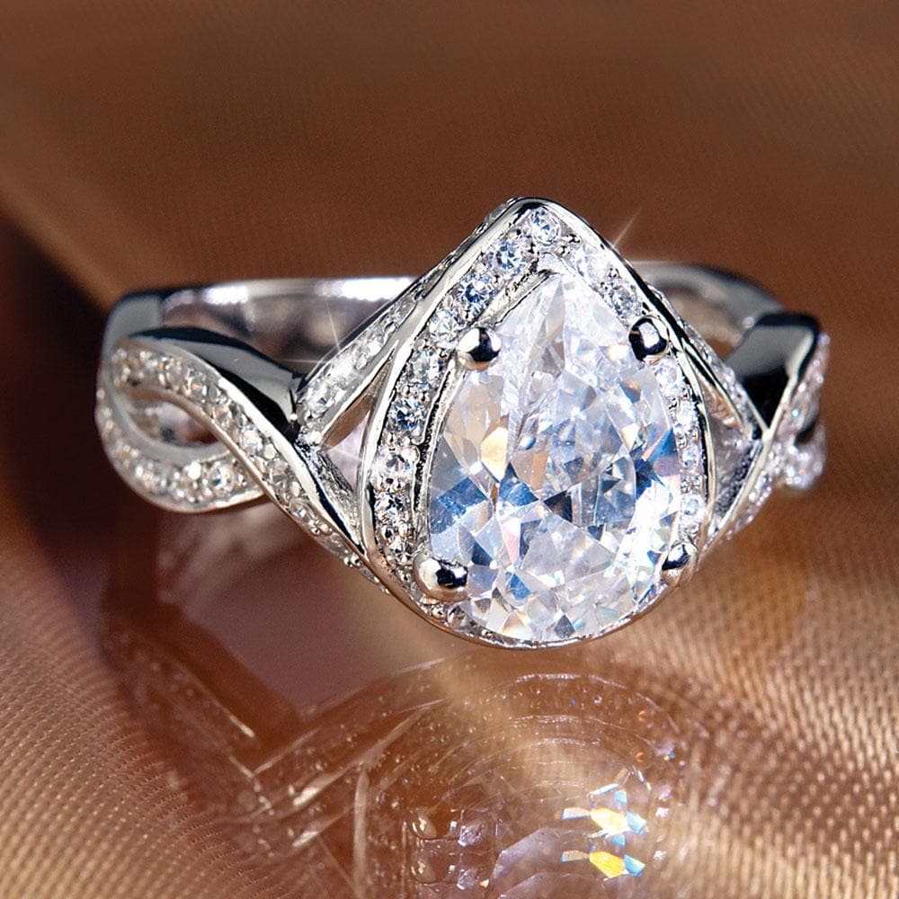 Pear Twist Ring featuring a sterling silver band with an intricate twisted design, showcasing a pear-shaped sparkling center stone surrounded by smaller clear gemstones.