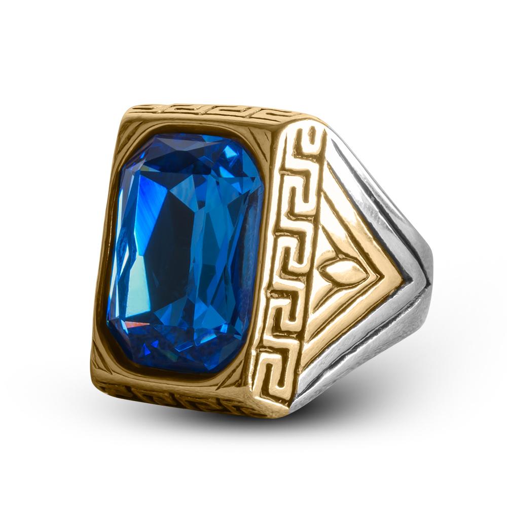 Defiance Blue Ring featuring a large blue gemstone set in a gold-plated stainless steel band with intricate geometric detailing, designed for men’s jewelry.